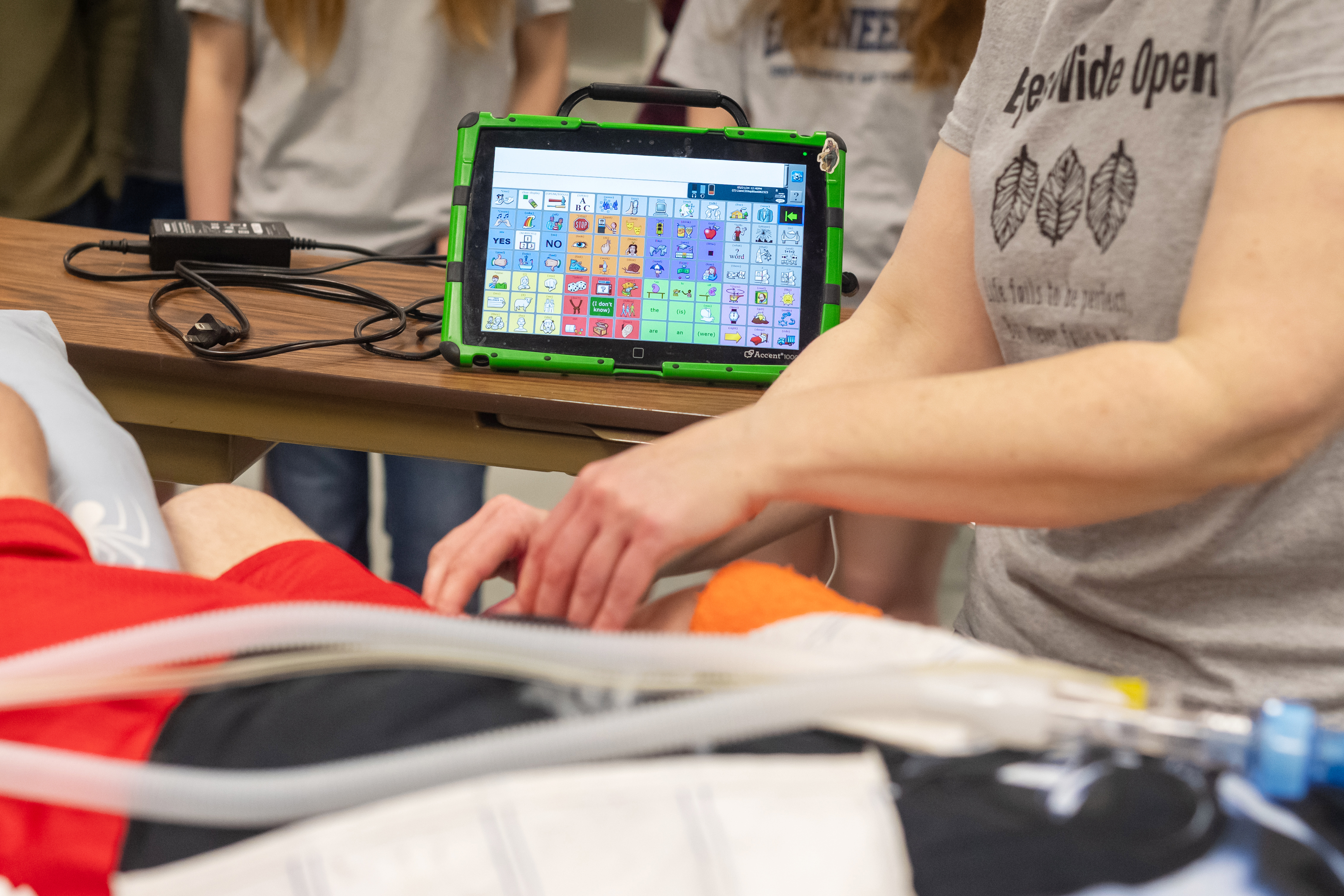 A closer look at Liam's communication device. To form sentences, he moves his fingers near two sensors to move a cursor and select words on the screen.