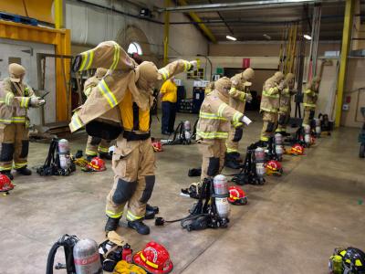 firefighting students putting on uniforms